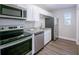 This renovated kitchen features stainless steel appliances, granite countertops, white cabinets and luxury vinyl flooring at 4226 Kelly Miller Ct, Orlando, FL 32811