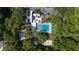 Aerial view of community pool and white modern building, parking lot, and surrounded by lush trees at 424 Club Dr, Winter Springs, FL 32708