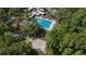 Aerial view of community pool and hot tub surrounded by lush trees and beach volleyball court at 424 Club Dr, Winter Springs, FL 32708