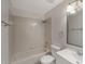 Well-lit bathroom with white tiled walls, a shower-tub combo and a sink with a mirror at 424 Club Dr, Winter Springs, FL 32708