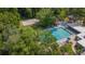 View of sparkling pool from above with volleyball court and seating surrounded by mature trees at 424 Club Dr, Winter Springs, FL 32708