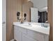 Modern bathroom vanity featuring a quartz countertop, mounted hair dryers, and vertical slat wall detailing at 4441 Ganesha Loop, Kissimmee, FL 34746
