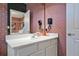 Contemporary bathroom vanity with white countertop, pink wallpaper, and modern fixtures at 4441 Ganesha Loop, Kissimmee, FL 34746