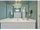 Bathroom featuring a vanity with a white countertop and cabinet, a shower with glass doors and a large mirror at 4441 Ganesha Loop, Kissimmee, FL 34746
