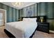 A cozy bedroom with designer wallpaper, elegant chandelier, and stylish dark furniture at 4441 Ganesha Loop, Kissimmee, FL 34746