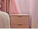 Close-up of a pink nightstand with gold hardware and a cozy bed in a princess-themed bedroom at 4441 Ganesha Loop, Kissimmee, FL 34746