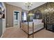 Elegant bedroom with a decorative accent wall, chandelier, and attached bathroom at 4441 Ganesha Loop, Kissimmee, FL 34746