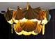 Close-up of a striking gold chandelier with detailed and unique leaf-like design at 4441 Ganesha Loop, Kissimmee, FL 34746