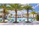 A view of the community pool and recreation area, featuring palm trees, lounge seating, and water play features at 4441 Ganesha Loop, Kissimmee, FL 34746