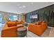 Modern living room featuring stylish orange sofas, unique accent walls, and marble floors at 4441 Ganesha Loop, Kissimmee, FL 34746