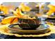 Close-up of a decorative place setting, featuring golden tableware, and black and gold bowl at 4441 Ganesha Loop, Kissimmee, FL 34746