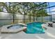 A private in-ground pool and attached hot tub feature clean tiling, and a screened enclosure at 4441 Ganesha Loop, Kissimmee, FL 34746