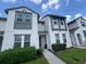 Stylish two-story townhome with modern gray trim, lush landscaping, and a welcoming front entrance at 454 Captiva Dr, Davenport, FL 33896