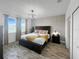 Serene main bedroom with wood floors, a patterned wall, and natural light at 454 Captiva Dr, Davenport, FL 33896
