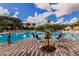 A community pool has chairs, umbrellas, and sign showing the distance to New York City and other places on a sunny day at 454 Captiva Dr, Davenport, FL 33896