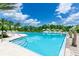 A swimming pool featuring clear water and palm trees with lounge chairs on the side under a beautiful sunny day at 454 Captiva Dr, Davenport, FL 33896