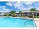 A swimming pool sits near a restaurant, lined with palm trees and colorful umbrellas, offering a refreshing and scenic view at 454 Captiva Dr, Davenport, FL 33896