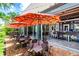 An outside patio in front of a burger restaurant features colorful umbrellas, outdoor seating, and lush greenery under a sunny sky at 454 Captiva Dr, Davenport, FL 33896