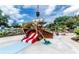 A vibrant splash pad offers a playful pirate ship slide and water features, surrounded by lush greenery on a sunny day at 454 Captiva Dr, Davenport, FL 33896