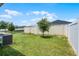 Backyard showcasing a green lawn, white vinyl fence and mature trees at 503 Meadow Pointe Dr, Haines City, FL 33844