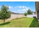 Spacious backyard with green grass, vinyl fence, and mature trees at 503 Meadow Pointe Dr, Haines City, FL 33844