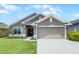 Charming single-story home with a well-manicured lawn, a two-car garage, and a welcoming entryway at 503 Meadow Pointe Dr, Haines City, FL 33844