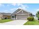 Well-maintained home with a two-car garage, lush green lawn, and beautiful landscaping at 503 Meadow Pointe Dr, Haines City, FL 33844
