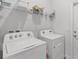 Laundry room features modern Whirlpool washer and dryer units and storage shelves at 503 Meadow Pointe Dr, Haines City, FL 33844