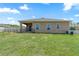 Home's backyard featuring a covered patio, green grass, and a fence with a dog run at 5515 Windsong Oak Dr, Leesburg, FL 34748
