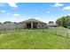 Wide view of the backyard area of the home with green grass and a patio at 5515 Windsong Oak Dr, Leesburg, FL 34748