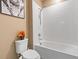 Clean bathroom featuring a shower-tub combination with white tile surround and modern fixtures at 5515 Windsong Oak Dr, Leesburg, FL 34748