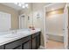 Bathroom features double sinks, dark cabinetry, and a separate toilet and tub/shower area at 5515 Windsong Oak Dr, Leesburg, FL 34748