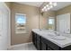 Bathroom with double sinks, large mirror and a scenic window offering great natural light at 5515 Windsong Oak Dr, Leesburg, FL 34748