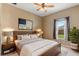 Comfortable bedroom with a neutral color scheme, large window, and stylish bedside lamps at 5515 Windsong Oak Dr, Leesburg, FL 34748