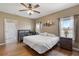 Bright bedroom with a ceiling fan, wood floors, and two windows for ample natural light at 5515 Windsong Oak Dr, Leesburg, FL 34748