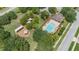 Aerial view of community pool and playground amenities with lush green trees at 5515 Windsong Oak Dr, Leesburg, FL 34748
