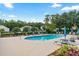 Relaxing community pool area with lounge chairs, palm trees, and a clear blue sky at 5515 Windsong Oak Dr, Leesburg, FL 34748