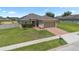 Charming home featuring well-maintained landscaping, a brick driveway, and a two-car garage at 5515 Windsong Oak Dr, Leesburg, FL 34748