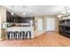 Modern kitchen with dark cabinets, granite countertops, and an island with barstool seating at 5515 Windsong Oak Dr, Leesburg, FL 34748