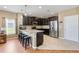 Open kitchen featuring dark cabinets, stainless steel appliances, and a breakfast bar with seating at 5515 Windsong Oak Dr, Leesburg, FL 34748