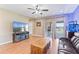 Cozy living room featuring a ceiling fan, wood floors, and sliding glass doors to the patio at 5515 Windsong Oak Dr, Leesburg, FL 34748