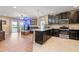Open floor plan that showcases a modern kitchen and comfortable living space with sliding glass doors at 5515 Windsong Oak Dr, Leesburg, FL 34748