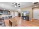 Spacious living room with wood floors, ceiling fan, and an open layout to the kitchen at 5515 Windsong Oak Dr, Leesburg, FL 34748