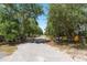 Scenic entrance to Bear Park with tree-lined road and charming wooden fencing at 5515 Windsong Oak Dr, Leesburg, FL 34748
