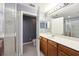 Bathroom vanity with wooden cabinets, framed mirror, and toilet area featuring a walk-in shower at 585 Cruz Bay Cir, Winter Springs, FL 32708
