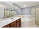 Bathroom featuring a garden tub and walk-in shower with a well-lit vanity area at 585 Cruz Bay Cir, Winter Springs, FL 32708