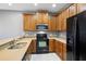 This kitchen features wood cabinets, black appliances, and stone countertops at 585 Cruz Bay Cir, Winter Springs, FL 32708