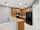 This kitchen features wood cabinets, black appliances, and tile floors at 585 Cruz Bay Cir, Winter Springs, FL 32708