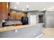 This kitchen features wood cabinets, black appliances, and a stone countertop island at 585 Cruz Bay Cir, Winter Springs, FL 32708