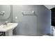 Small powder room with a pedestal sink, round mirror, and a towel bar, maximizing the limited space at 585 Cruz Bay Cir, Winter Springs, FL 32708
